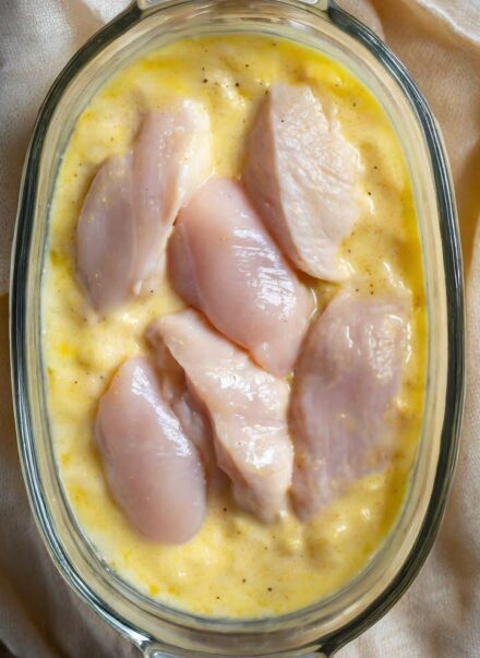 Mom lays raw chicken over creamy mixture in casserole, serves tasty dinner in no time