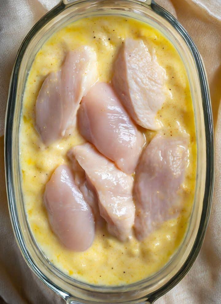 Mom lays raw chicken over creamy mixture in casserole, serves tasty dinner in no time